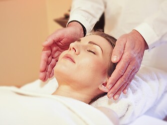 Woman enjoying relaxing craniosacral therapy at health hotel Eschenhof in Bad Kleinkirchheim in the Nock Mountains.