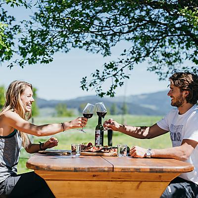Ein Paar bei einer Wanderpause mit einem Glas Wein in den Nockbergen